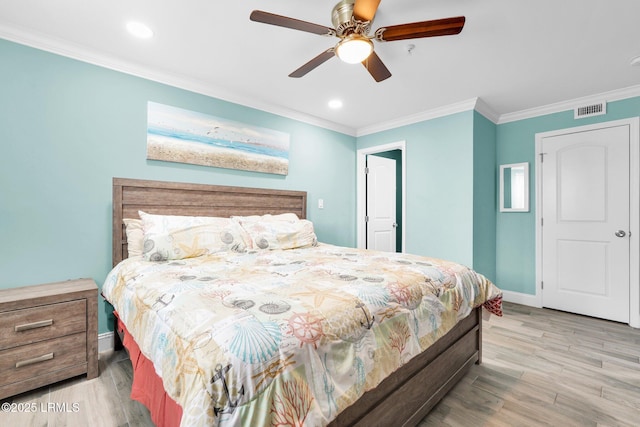 bedroom featuring ceiling fan, ornamental molding, and light wood-type flooring