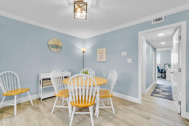 dining area featuring ornamental molding and light wood-type flooring