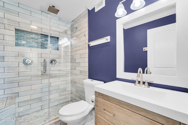 bathroom with vanity, toilet, and a shower with shower door