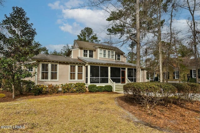 rear view of property with a sunroom and a yard