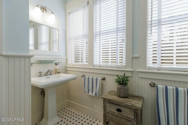 bathroom with a wainscoted wall and a sink