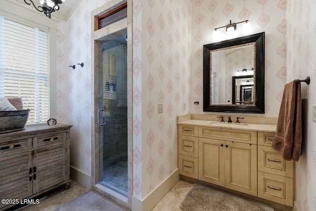 bathroom featuring wallpapered walls, vanity, baseboards, and a stall shower