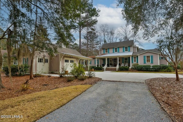 view of front of property with gravel driveway, covered porch, and an attached garage