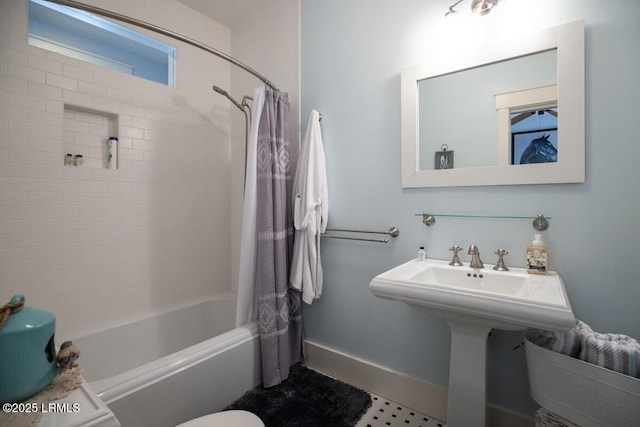 bathroom with shower / bathtub combination with curtain and baseboards