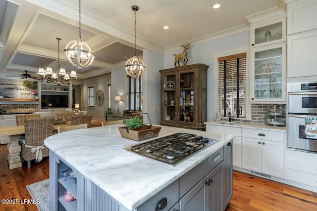 kitchen featuring light wood-style floors, open floor plan, stainless steel appliances, and ceiling fan with notable chandelier