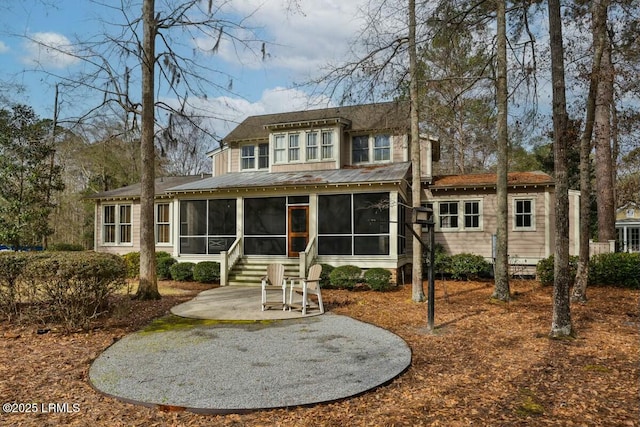 rear view of property featuring a sunroom