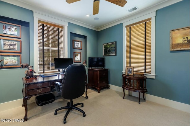 office with carpet flooring, a ceiling fan, baseboards, visible vents, and crown molding