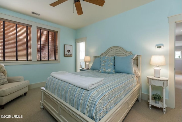 carpeted bedroom with baseboards, visible vents, and a ceiling fan