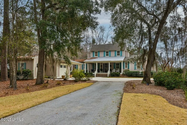 view of front facade with a porch and gravel driveway