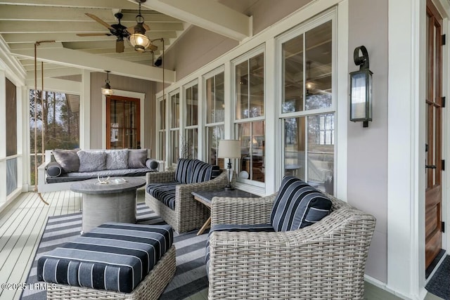 sunroom / solarium featuring a ceiling fan and beam ceiling