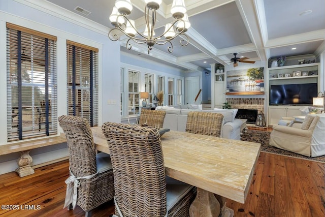 dining room with coffered ceiling, wood finished floors, visible vents, a brick fireplace, and beamed ceiling