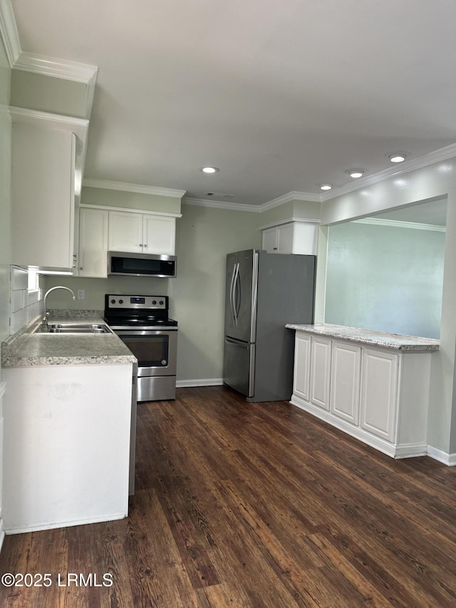 14007 Kader St, Beaufort, SC 29906 - kitchen with appliances with stainless steel finishes, dark wood-type flooring, white cabinets, ornamental molding, and recessed lighting