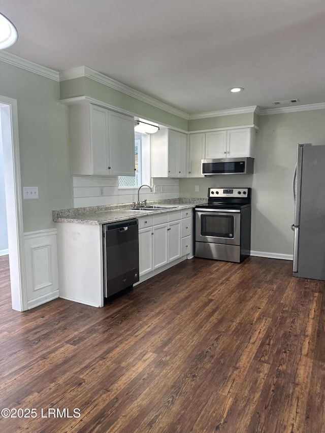 14007 Kader St, Beaufort, SC 29906 - kitchen featuring stainless steel appliances, ornamental molding, dark wood-style floors, white cabinetry, and light stone countertops
