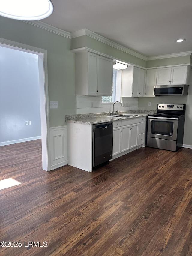 14007 Kader St, Beaufort, SC 29906 - kitchen featuring stainless steel appliances, crown molding, dark wood-type flooring, white cabinets, and light stone countertops