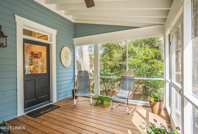 unfurnished sunroom featuring vaulted ceiling with beams and a ceiling fan