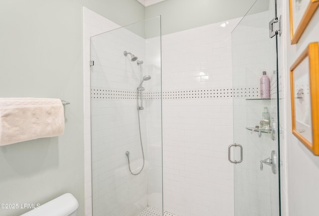 full bathroom featuring toilet and a shower stall