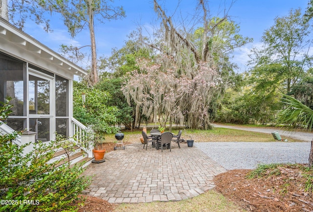 view of patio / terrace with outdoor dining area and a sunroom