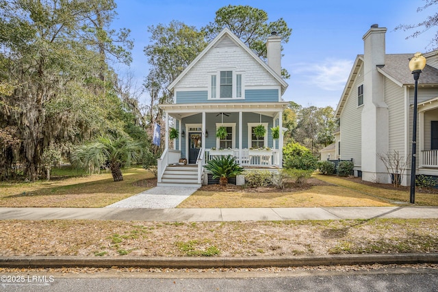 view of front of property featuring covered porch and a front lawn