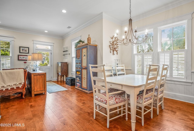 dining space with recessed lighting, an inviting chandelier, wood finished floors, and ornamental molding