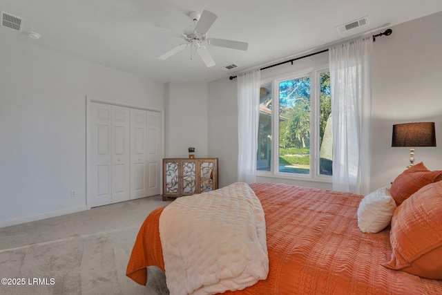 bedroom with multiple windows, light carpet, ceiling fan, and a closet