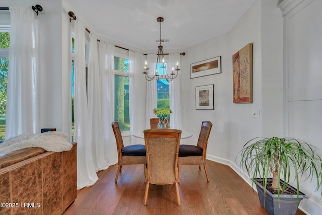 dining space featuring hardwood / wood-style floors and a chandelier