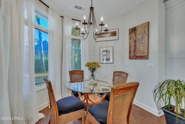 dining space with plenty of natural light, dark hardwood / wood-style floors, and a chandelier