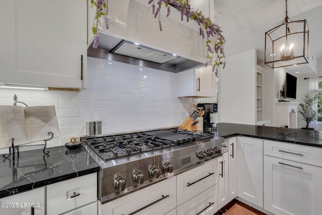 kitchen featuring ventilation hood, pendant lighting, white cabinets, and dark stone counters