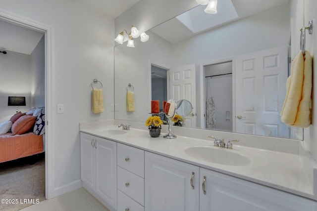 bathroom with vanity, a skylight, and tile patterned floors