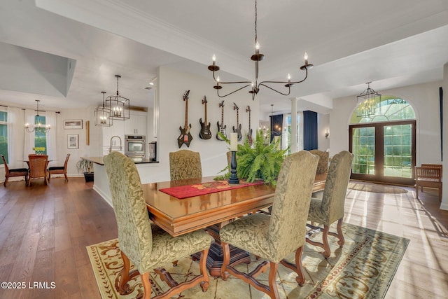 dining room featuring an inviting chandelier, sink, hardwood / wood-style flooring, and french doors