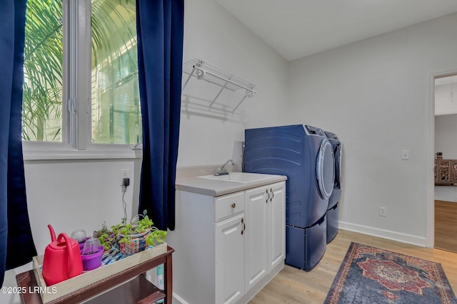 washroom featuring cabinets, independent washer and dryer, sink, and light hardwood / wood-style floors