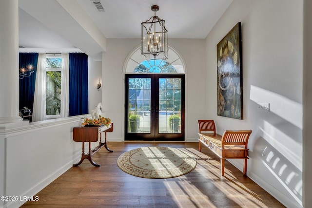 entryway featuring hardwood / wood-style flooring, a chandelier, and french doors