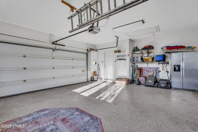 garage featuring a garage door opener and stainless steel fridge with ice dispenser