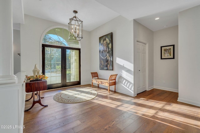 entryway with an inviting chandelier, hardwood / wood-style floors, and french doors