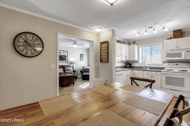 kitchen featuring light wood-type flooring, a textured ceiling, white cabinets, and white appliances