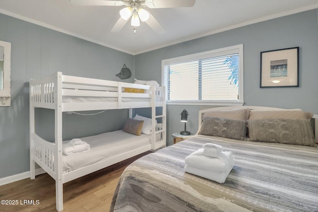 bedroom featuring hardwood / wood-style floors, crown molding, and ceiling fan