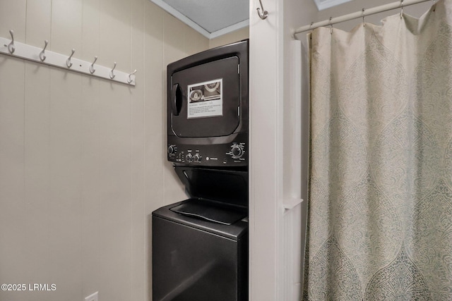 laundry area featuring ornamental molding and stacked washing maching and dryer