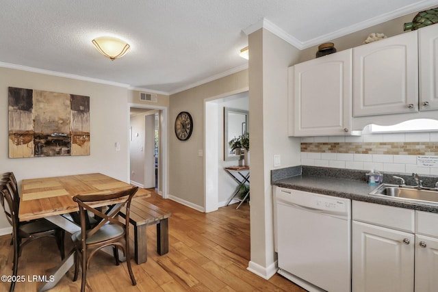 kitchen with sink, dishwasher, white cabinets, decorative backsplash, and light wood-type flooring