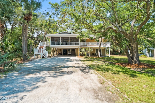 738 Marlin Dr, Fripp Island, SC 29920 - raised beach house featuring driveway, a carport, a sunroom, stairway, and a front yard