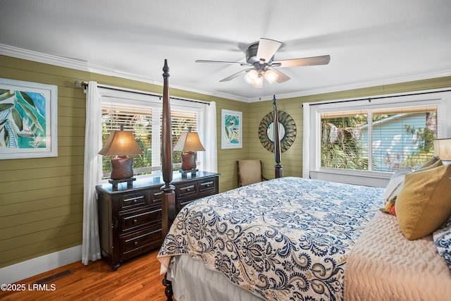 738 Marlin Dr, Fripp Island, SC 29920 - bedroom featuring wood finished floors, ornamental molding, baseboards, wooden walls, and a ceiling fan