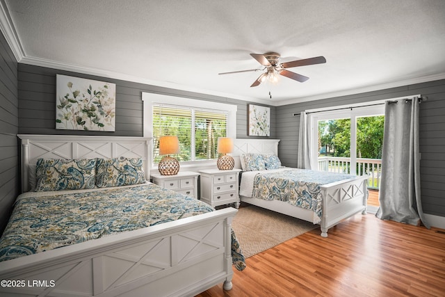738 Marlin Dr, Fripp Island, SC 29920 - bedroom featuring multiple windows, crown molding, access to outside, a textured ceiling, and light wood-type flooring