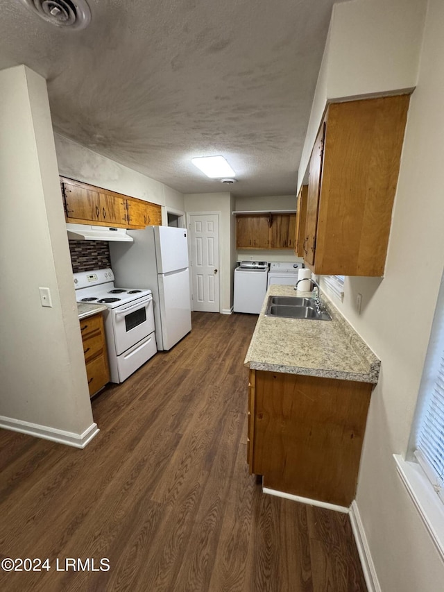 kitchen featuring sink, white appliances, a textured ceiling, dark hardwood / wood-style flooring, and washer / clothes dryer