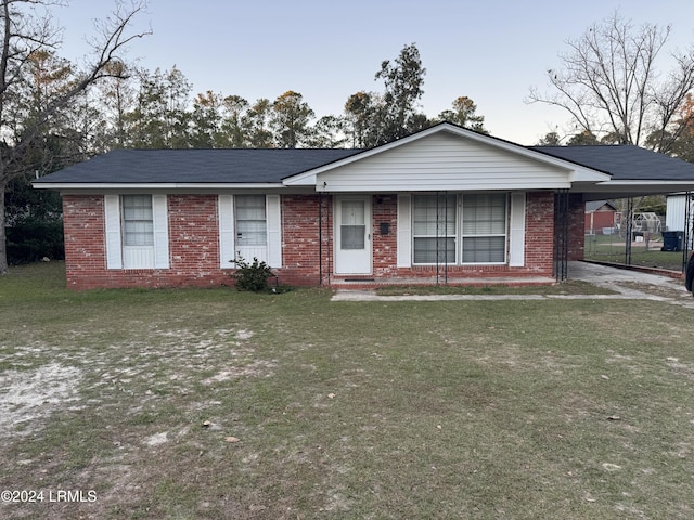 ranch-style home with a carport and a front yard