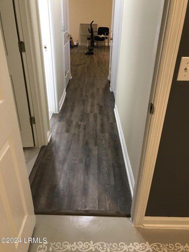 corridor with dark hardwood / wood-style flooring