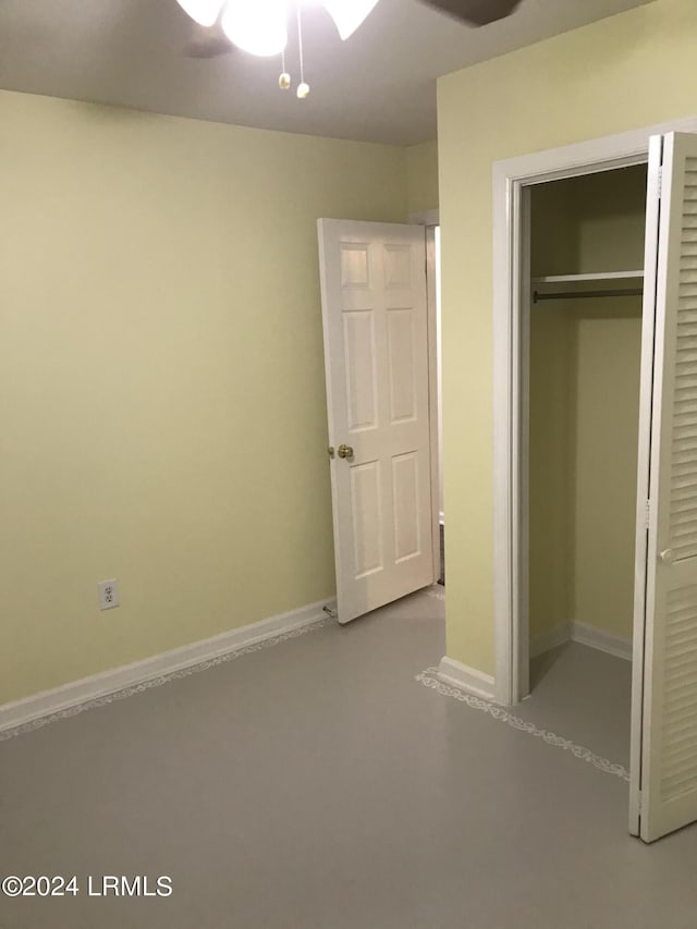 unfurnished bedroom with ceiling fan and a closet