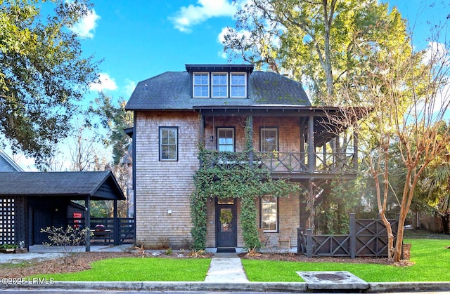 view of front of home with a balcony and a front lawn