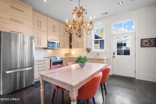 dining space featuring a chandelier and sink