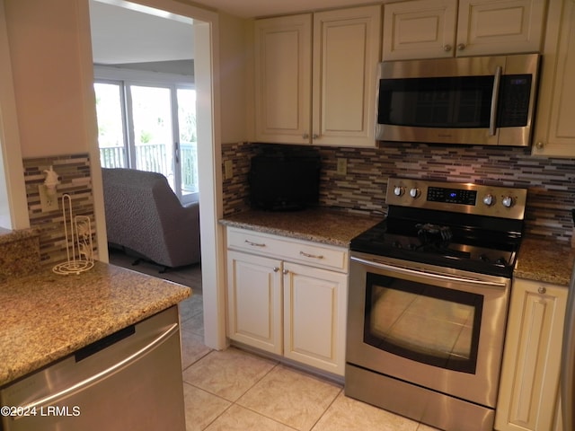 kitchen featuring stainless steel appliances, tasteful backsplash, light tile patterned floors, and stone counters