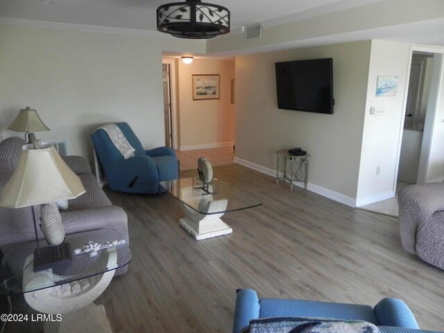 living room with hardwood / wood-style floors and crown molding