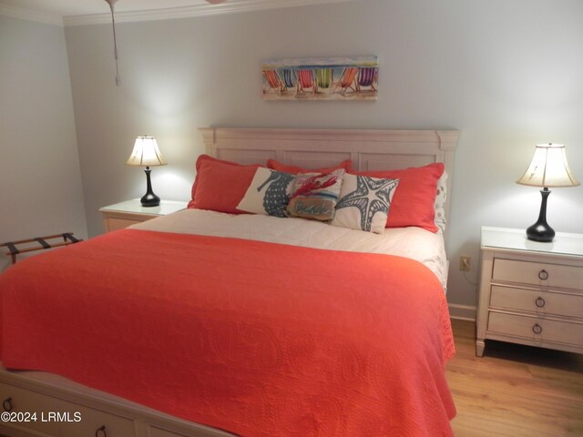 bedroom featuring ornamental molding and light hardwood / wood-style floors