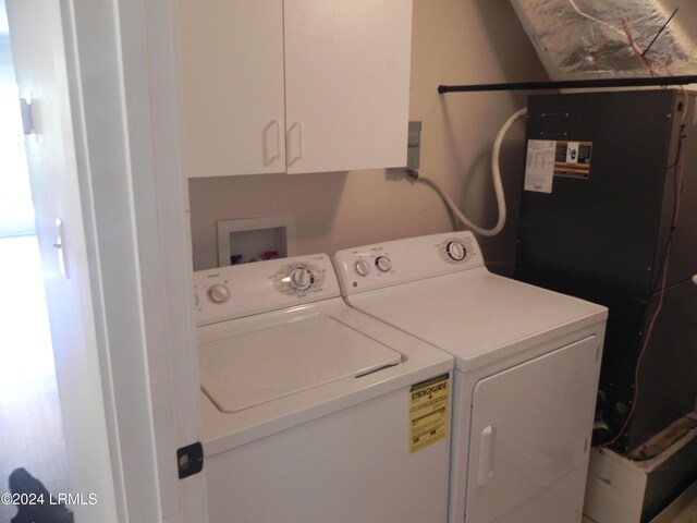 laundry area with washer and dryer and cabinets